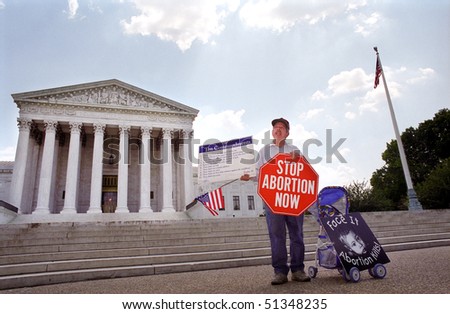 WASHINGTON, DC - MAY 14: An anti-abortion protester holds a stop sign and the Ten Commandments on the sidewalk in front of the U.S. Supreme Court on May 14, 2001 in Washington, D.C.