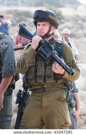 AL-WALAJA  - NOVEMBER 13: An Israeli soldier with a tear gas gun stands by during a protest against Israel\'s separation wall on Nov. 13, 2010 in Al-Walaja.