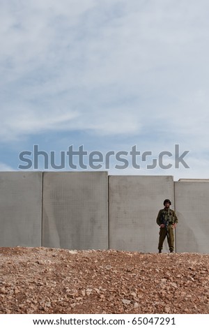 AL-WALAJA - NOVEMBER 13: An Israeli soldier stand in front of the Israeli separation barrier which threatens to encircle Al-Walaja, on Nov. 13, 2010.