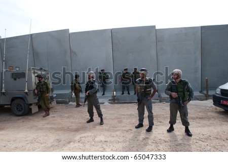 AL-WALAJA - NOVEMBER 13: On Nov. 13, 2010, Israeli soldiers stand in front of the Israeli separation barrier which threatens to encircle the West Bank town Al-Walaja.