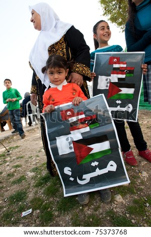 NABI SAMUEL, OCCUPIED PALESTINIAN TERRITORIES - APRIL 1: Palestinian unidentified children hold signs with the flags of Tunisia, Egypt, Libya, Yemen, Palestine and the question in Arabic: \