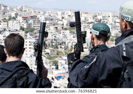JERUSALEM - APRIL 22: Unidentified Israeli riot police wield tear gas guns during clashes with Palestinian youth in the East Jerusalem neighborhood of Al-Isawiyya on April 22, 2011.