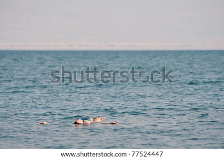 EIN GEDI, ISRAEL - APRIL 9: A swimmer floats on her back in the exceptionally salty waters of the Dead Sea at Ein Gedi National Park, Israel, on April 9, 2011.