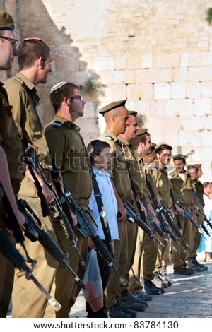 JERUSALEM - AUGUST 24: An unidentified ultra-orthodox boy stands with ranks of the Israeli Army\'s Marva program, which brings foreign Jews to receive military training, at the Western Wall on Aug. 24, 2011.