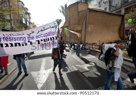 TEL AVIV - DECEMBER 9: Activists carry a cardboard bulldozer to protest the demolition of Palestinian homes as thousands take part in the annual human rights march in Tel Aviv on Dec 9, 2011.