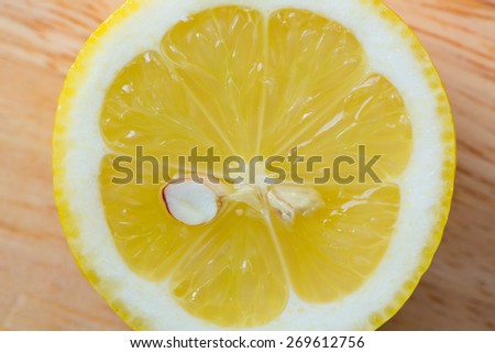 Slice of lemon isolated on wooden background