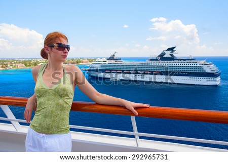 Beautiful woman is standing on the open deck of luxury cruise ship. Grand Cayman island