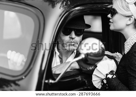 Retro couple with black old car