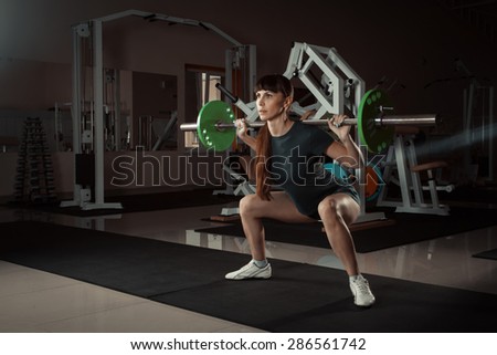 Young  girl in the gym doing squat