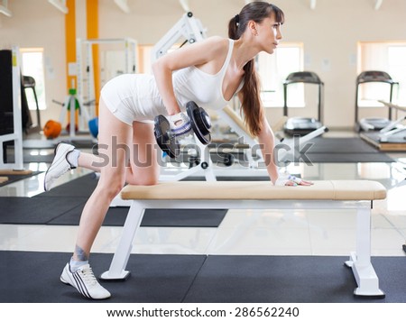 Female fitness girl exercising indoor in fitness center.