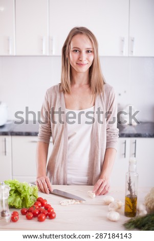 Young Woman Cooking in the kitchen.  Dieting vegetarian concept. Healthy Lifestyle. Cooking At Home. Prepare Food