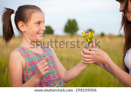 Daughter giving mother flowers
