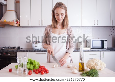 Young Woman Cooking in the kitchen. Dieting vegetarian concept. Healthy Lifestyle. Cooking At Home. Prepare Food