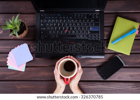 Coffee mug in hand. Woman working in the office regarding accounting