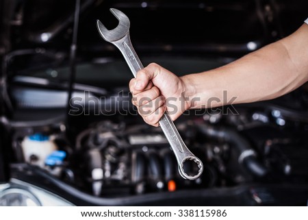 Hand of car mechanic with wrench. Auto repair service