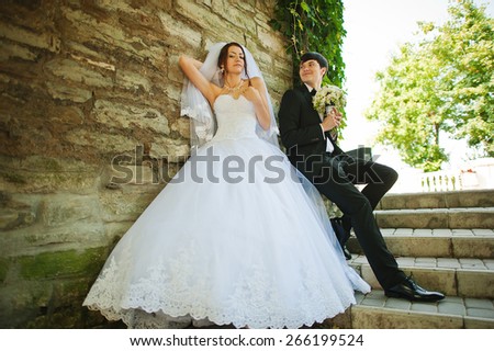 Young beautiful wedding couple at the wall