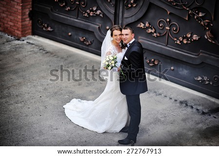 wedding couple near wrought iron gates