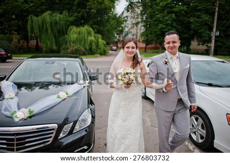 Wedding couple in love near wedding cars