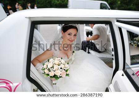 happy bride on wedding limousine
