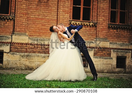 groom tenderly kissing his wife on the neck