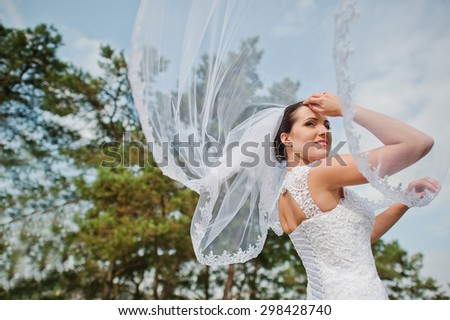 brunette bride with veil and bouquet