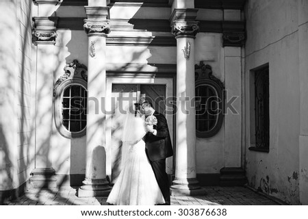 Gorgeous married couple kissing background old columns with shadow