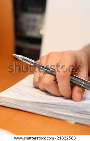 A hand with the pen.