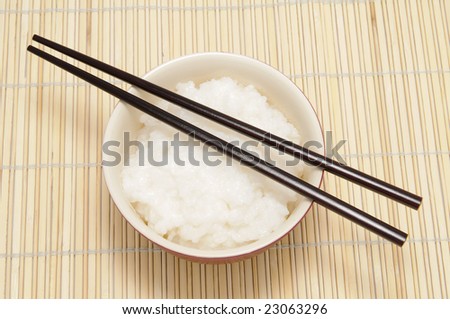 chopsticks and tureen with rice on bamboo tray