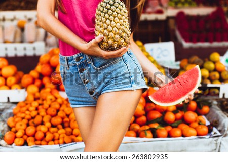 Beauty Model Girl takes Juicy Watermelon and  Pineapple. Beautiful Joyful teen girl with freckles.Having fun on fruit market.Watermelon  Slices.