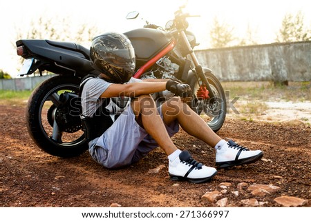 Young sportsman posing on helmet opposite the sunset.Extreme sport,Motocross man,sportsman on motorcycle wear helmet,motocross clothes ,cool motorcycles man in sunglasses and helmet