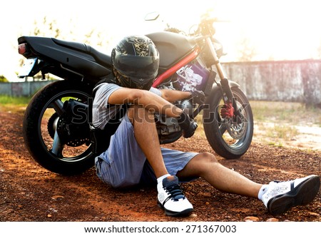 Young sportsman posing on helmet opposite the sunset.Motorcycle extreme sport.sportsman on motorcycle wear helmet,motocross clothes ,cool motorcycles man in sunglasses and helmet
