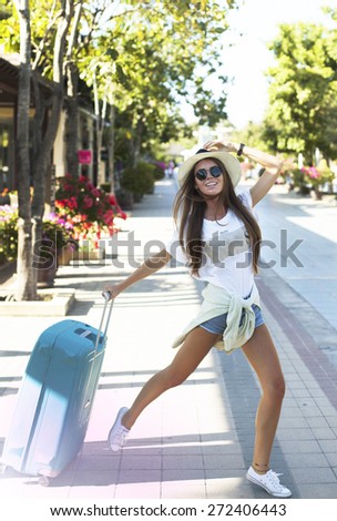 Very emotional woman having  fun  in  airport.crazy about her new trip, screaming laughing and having fun with bright luggage, enjoy travel together.Summer mood,urban background,fashion look
