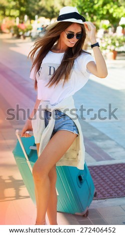 Very emotional woman having  fun  in  airport.happy of her new trip, screaming laughing and having fun with bright luggage, enjoy travel together.Summer mood,urban background,fashion look.