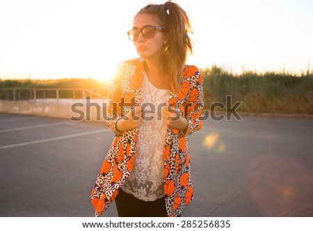 Outdoor fashion and lifestyle portrait of trendy woman posing at sunset in trendy jacket and summer bright outfit,enjoy her summer holidays,vacation outfit,summer look,trendy girl,accessories,urban