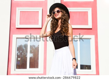 Outdoor fashion portrait of young happy pretty smiling woman,walk around the city streets,wear stylish street style outfit hat and trendy sunglasses,positive mood.Urban city style,summer accessories