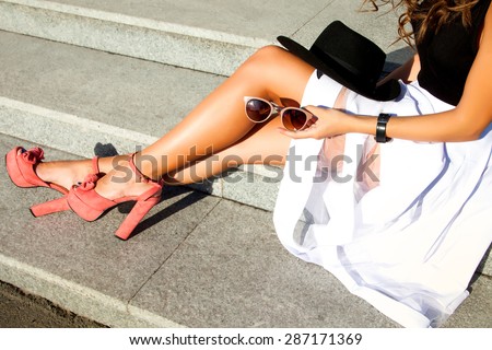 close-up portrait of fashionable and  trendy young  lady,posing at the city,glamour accessories sunglasses,summer shoes,perfect legs,summer collection of shoes,stylish sandals,summer dress code