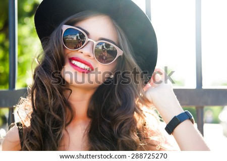 Fashion outdoor portrait of  summer hipster woman wear summer outfit and having fun on the street