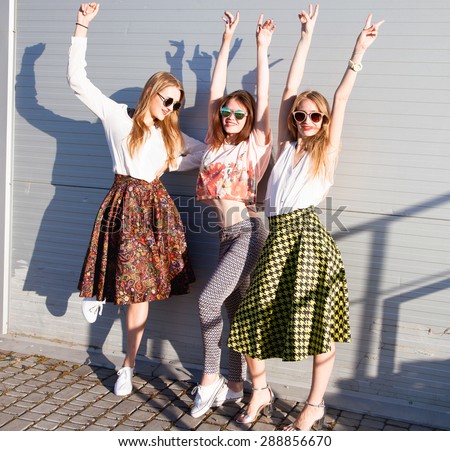 Summer lifestyle portrait of tree girls going crazy, screaming, laughing having fun together, put hands up to the sky.wearing white tops and sunglasses, ready for party, joy, fun.summer friends