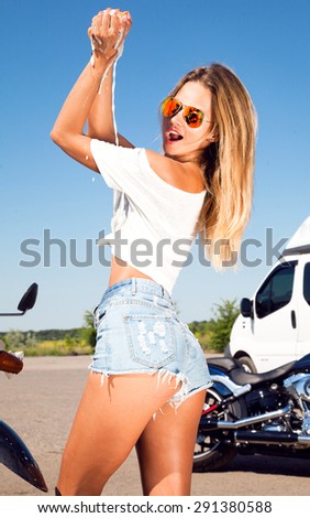 Portrait of beautiful sexy brunette in wet shirt,motorcycle washing,wet chic,american car wash,denim shirts,aviator sunglasses