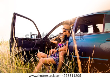 Portrait of young man with his beautiful girlfriend on a road trip.Couple driving in nature in a open car.Young man and young woman on road trip,Loving young couple with sea shore in background.