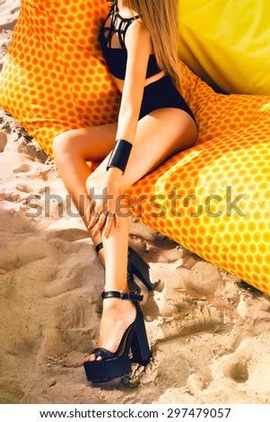 Indoor fashion portrait of young curled brunette beautiful woman with bright make up having fun,wearing sexy casual sportive outfit,urban background,bright colors.summer hight heels,assessory fashion