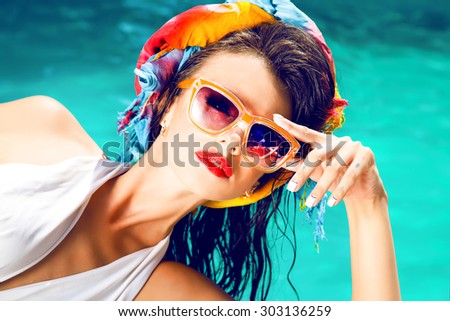 Outdoor fashion portrait of glamour lady enjoying her vacation on luxury pool on hot tropical island,hot summer fashion accessory,stylish sunglasses,bikini.Sexy perfect fit body woman.red lips,party