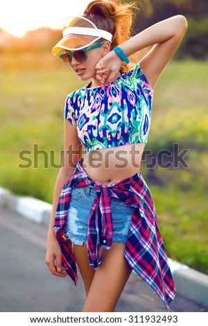 Fashion portrait of beautiful hippie young woman wearing boho chic clothes and summer hat outdoors.Soft warm vintage color tone.Fashion brunette model in nice clothes.Wearing coat,handbag,ripped jeans