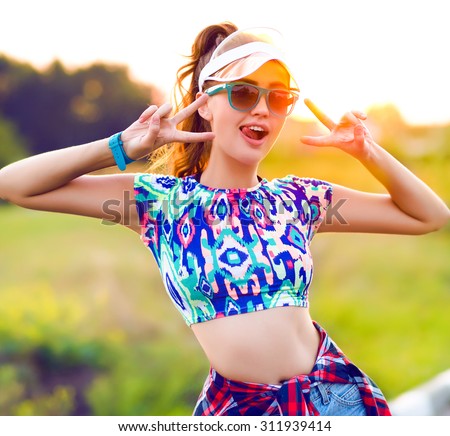 Freedom concert portrait of cool woman posing alone and having fun,feels good,girl teen hipster outfit, posing on sunset background,bright summer toned portrait.tongue,flirt woman,look good,happiness