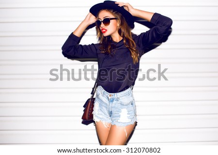 Closeup attractive beautiful woman with fluffy brunette long hairs,smiling, having fun on the white wall,wearing vintage sunglasses,outfit and hat,vacation style,autumn look,hairstyle,hairdresser