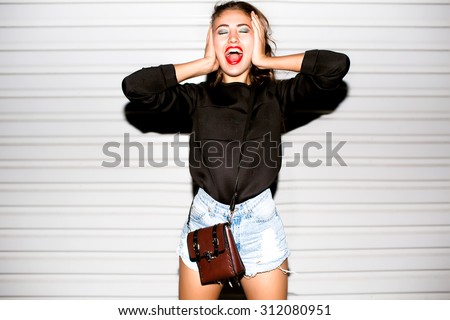 Close up lifestyle portrait of bad girl hipster girl making funny face and showing her tongue.Laughing portrait,crazy mood,covers ears and shouts,beats,beat box,music speakers,loud music,deep house