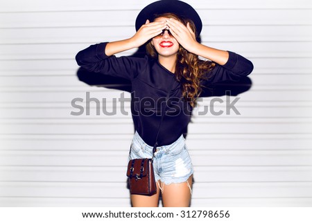 Funny lifestyle portrait of crazy girl closed her eyes,emotional and happy mood,chic clothes and summer hat outdoors.Soft warm vintage color tone.Stylish sweater and hat.smiling laughing,autumn colors
