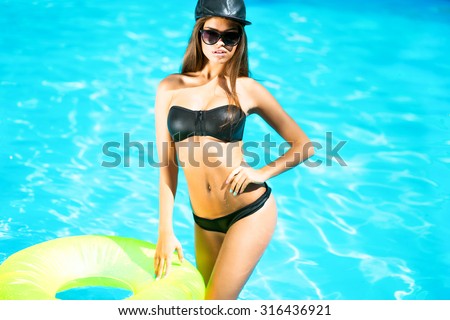Sexy woman in bikini enjoying summer sun and tanning during holidays in pool with a cocktail.pretty fashion sport woman posing in summer on tropic island in hot weather in bikini on pool party
