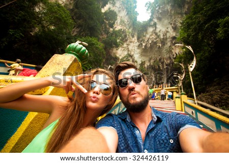 Close-up portrait of beautiful travel couple,wear casual hipster outfit,make selfie of their trip,positive mood,happy couple,couple wear sunglasses,shows tongue,crazy self portrait,emotional people