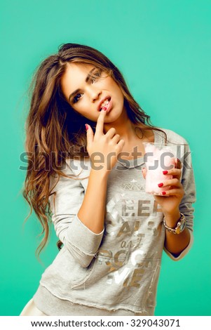 Young blonde hipster girl eating a delicious ice cream in summer hot weather in sunglasses have fun and good mood looking in camera and smiling.funny woman eat sweets and showing tongue,full lips